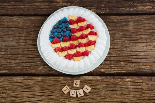 Overhead view of date blocks and fruitcake on wooden table with 4th july theme