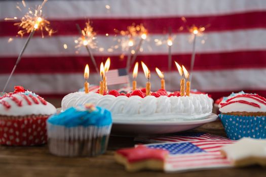 Patriotic 4th of july cake and cupcake arranged on wooden table