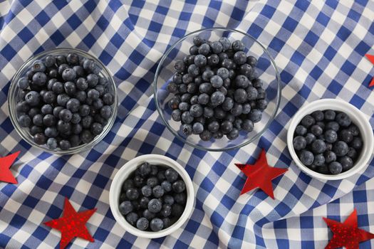 Black berries in bowls with 4th july theme on wooden table