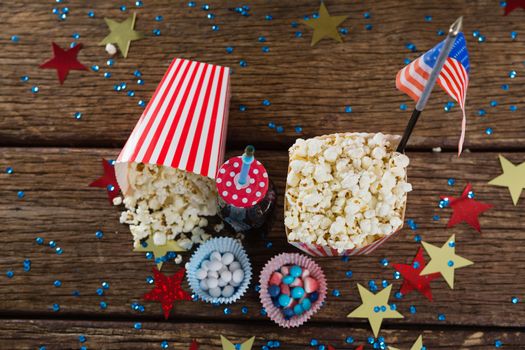Popcorn, sweet food and cold drink decorated with 4th july theme on wooden table