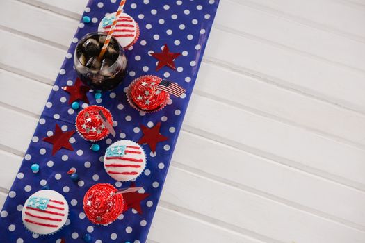 Decorated cupcakes and cold drink with 4th july theme on wooden table