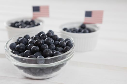 Black berries in bowls with 4th july theme on wooden table