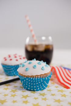 Close-up of drink and cupcake with 4th july theme on table