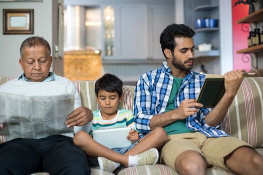 Family relaxing while sitting on sofa in living room at home
