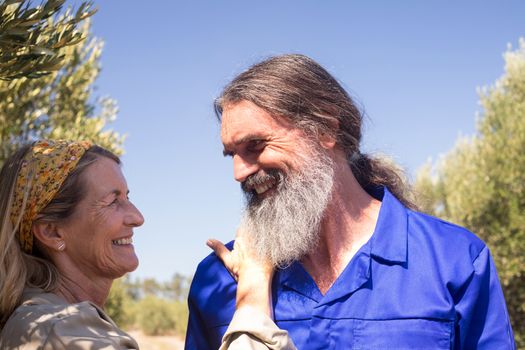 Romantic couple looking at each other in olive farm on a sunny day