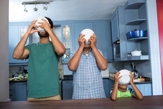 Family having breakfast while standing at table in kitchen