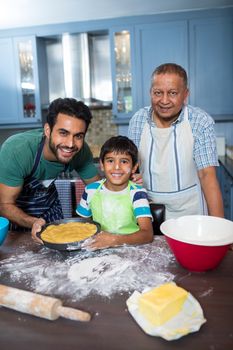Portrait of happy family preparing food in kitchen at home