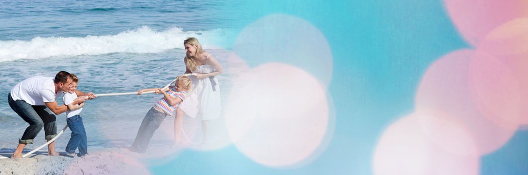 Digital composite of Family at beach doing tug of war with blue and pink bokeh transition