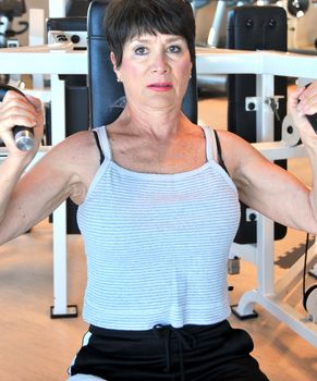 Mature female beauty working out inside a health club.