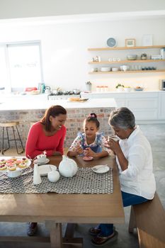 Multi-generation family having breakfast in dining table at home