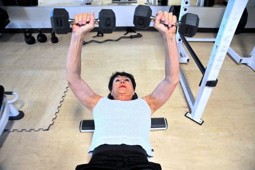 Mature female beauty working out inside a health club.