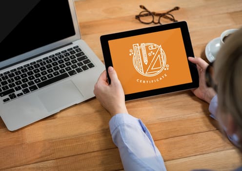 Digital composite of Person holding a tablet with education icon on the screen