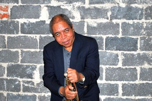 African american jazz trumpet player with his horn in studio basement.