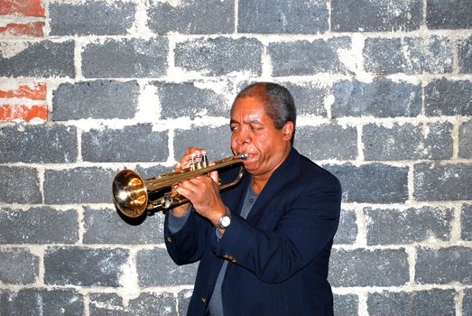 African american jazz trumpet player with his horn in studio basement.