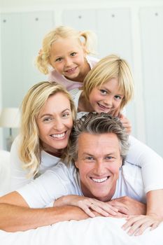 Portrait of happy family having fun on bed in the bed room at home