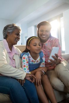 Happy family using mobile phone in living room at home