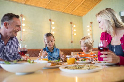 Family talking while having dinner at restaurant