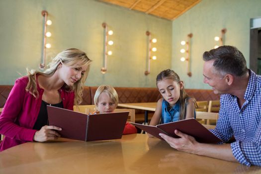 Family reading menu while sitting at table in restaurant