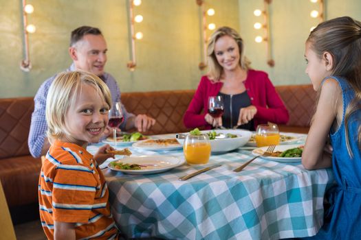 Portrait of boy sitting with family at restaurant