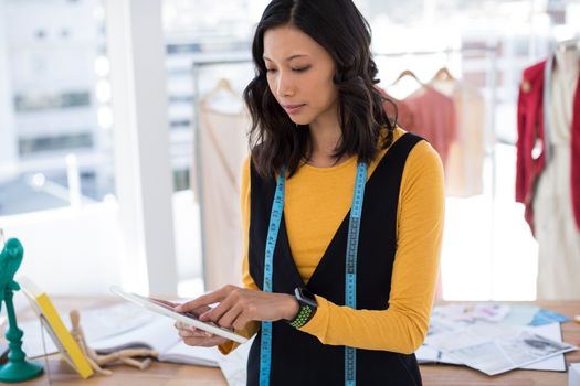 Fashion designer using digital tablet in office