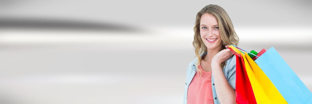 Digital composite of Shopper with bags against blurry grey abstract background