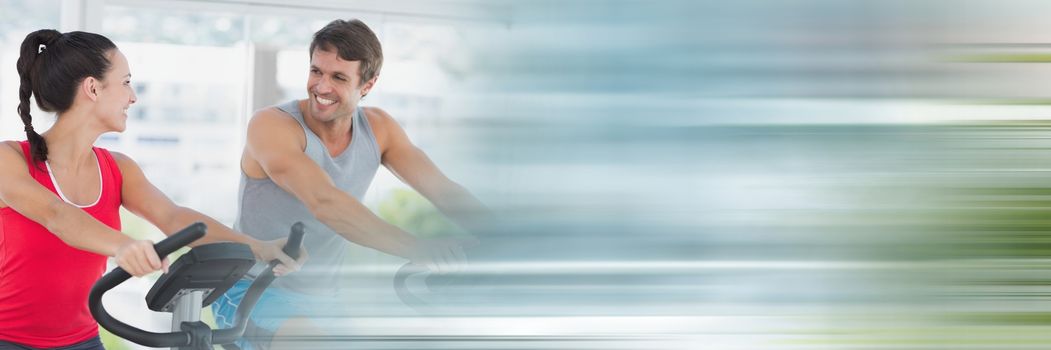Digital composite of People smiling on gym bikes with blurry motion blur
