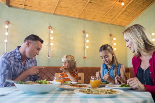 Smiling family having food at restaurant