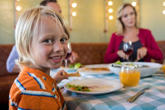 Portrait of boy dining with family at restaurant