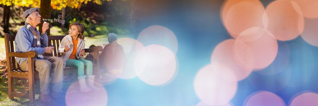 Digital composite of Family in park blowing bubbles with blue and orange bokeh transition