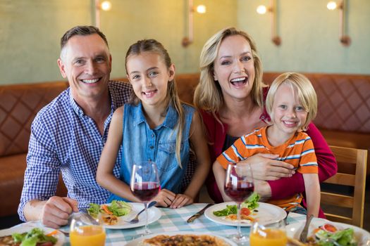 Portrait of cheerful family sitting at restaurant