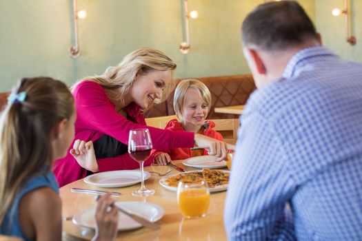 Family enjoying appetizer while sitting at table in restaurant