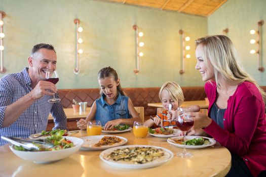 Happy family talking while having dinner at restaurant