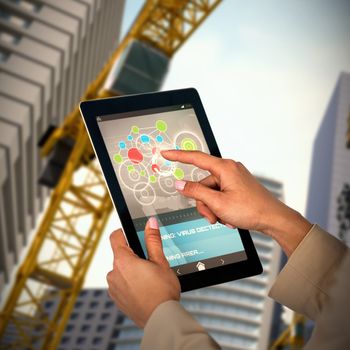Businesswoman using digital tablet against 3d image of buildings and cranes