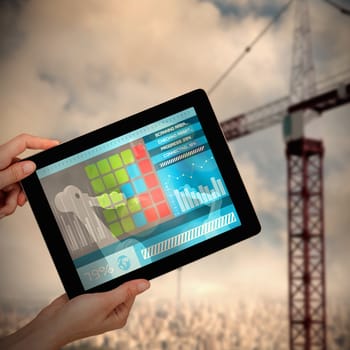 Hands holding digital tablet against white background against 3d image of red crane in city