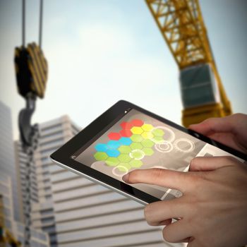 Close-up of businesswoman holding digital tablet against 3d image of cranes by buildings
