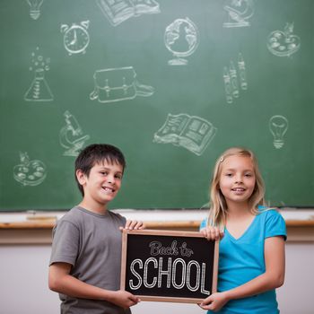 Back to school message against cute pupils showing chalkboard