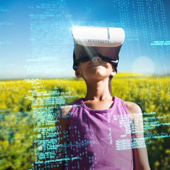 Boy wearing virtual reality glasses against yellow mustard field