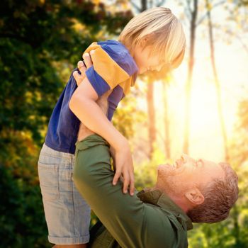 A father holding his son in the air against trees in forest 