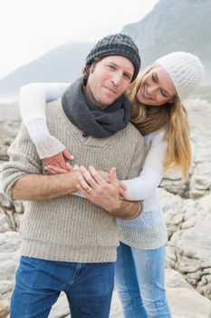 Portrait of a happy romantic young couple standing together on a rocky landscape