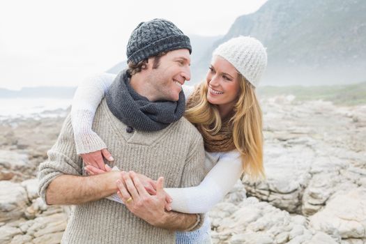 Happy romantic young couple standing together on a rocky landscape