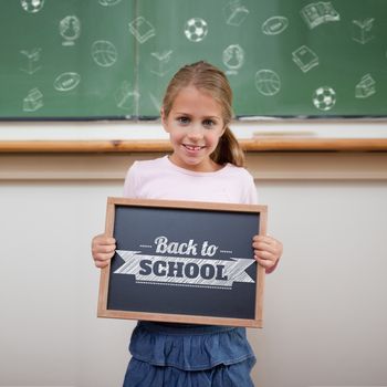 Back to school message against cute pupil showing chalkboard