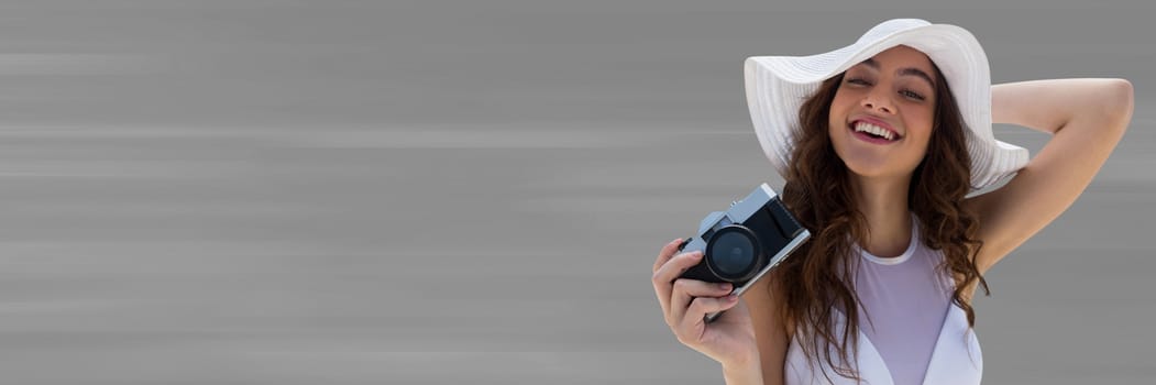 Digital composite of Millennial woman in summer hat with camera against blurry grey background