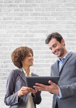 Digital composite of Happy business people using a tablet against white wall