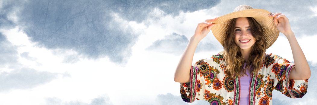 Digital composite of Millennial woman in summer clothes holding hat against cloudy sky