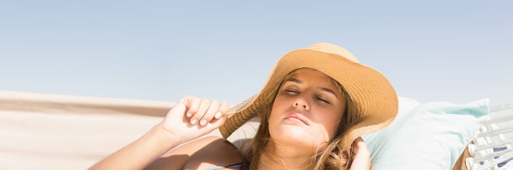 Digital composite of Millennial woman with sun hat asleep on hamoc against Summer sky
