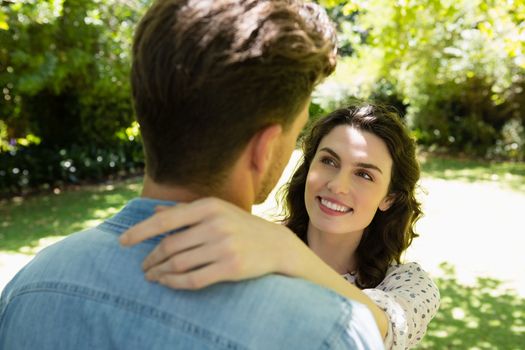 Romantic couple looking face to face in garden on a sunny day