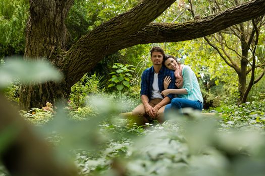 Romantic couple sitting on bench in garden on a sunny day