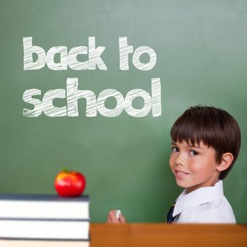 Back to school message against cute pupil holding chalk