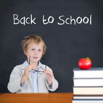 Cute pupil holding glasses against back to school message