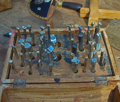 Wooden box with tools used for engraving ornaments on leather